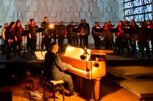 Der Chor Salt o vocale beim Konzert Salto Natale im Gebetshaus Bad Rotenfels. Im Vordergrund Achim Rheinschmidt als Chorleiter am Flügel