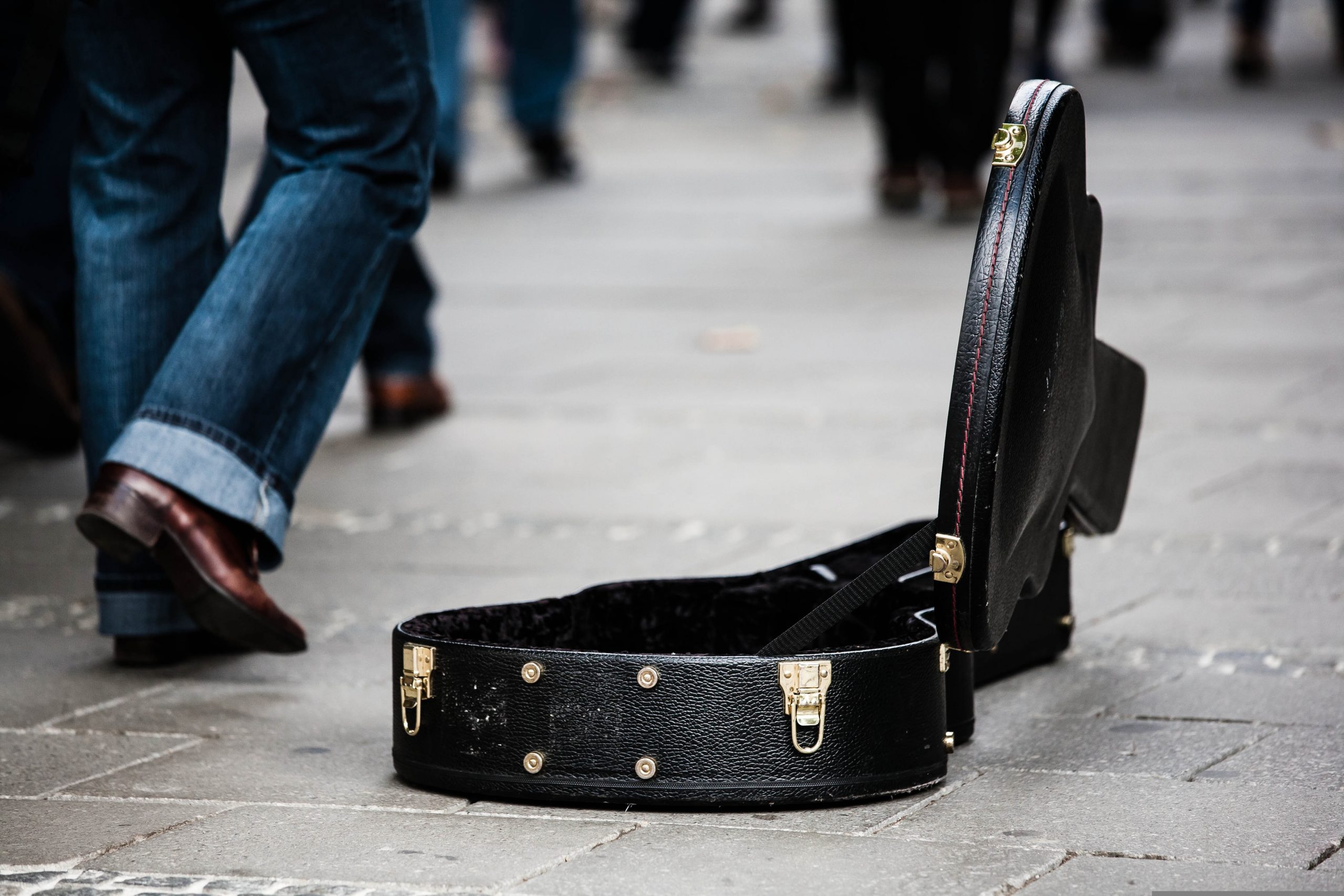 geöffneter Gitarrenkoffer in Fußgängerzone